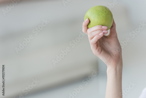 cropped shot of woman holding fresh green apple