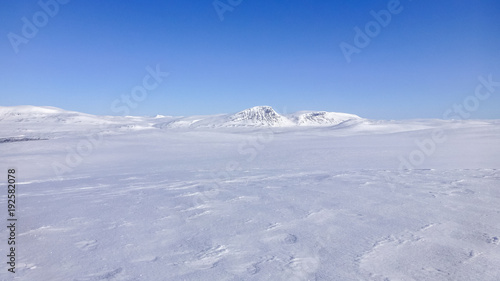 Large open field with snow and mountains on the horizon in northern Sweden near the polar circle. © Forenius