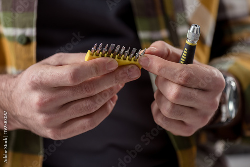 Wallpaper Mural cropped image of hands holding screwdriver and its attachments Torontodigital.ca