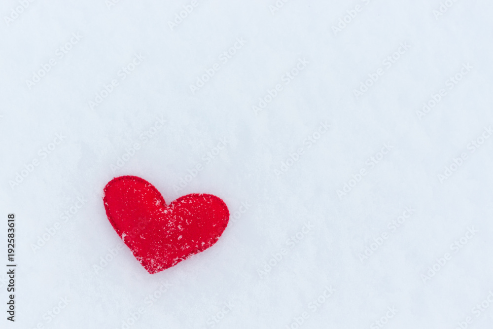 red felt heart figure on snow, winter day