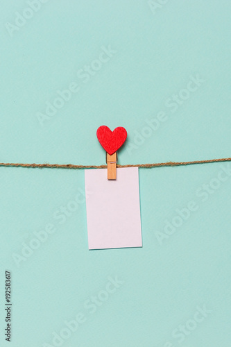 white piece of paper pinned to rope with clothespin decorated with wooden heart