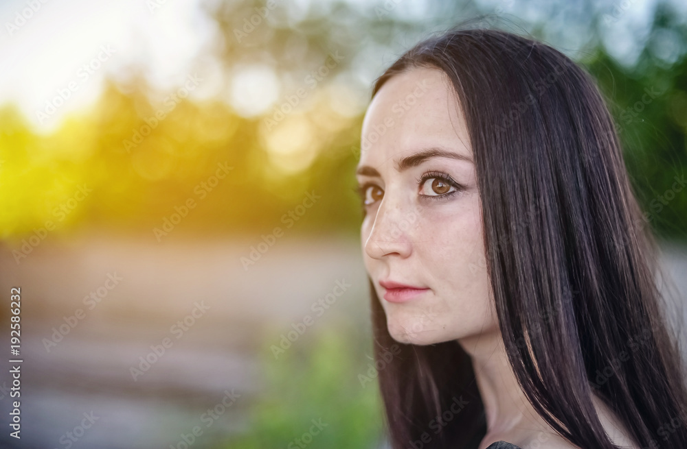girl will wrinkle to the left against a background of green trees girl will wrinkle to the left against a background of green trees