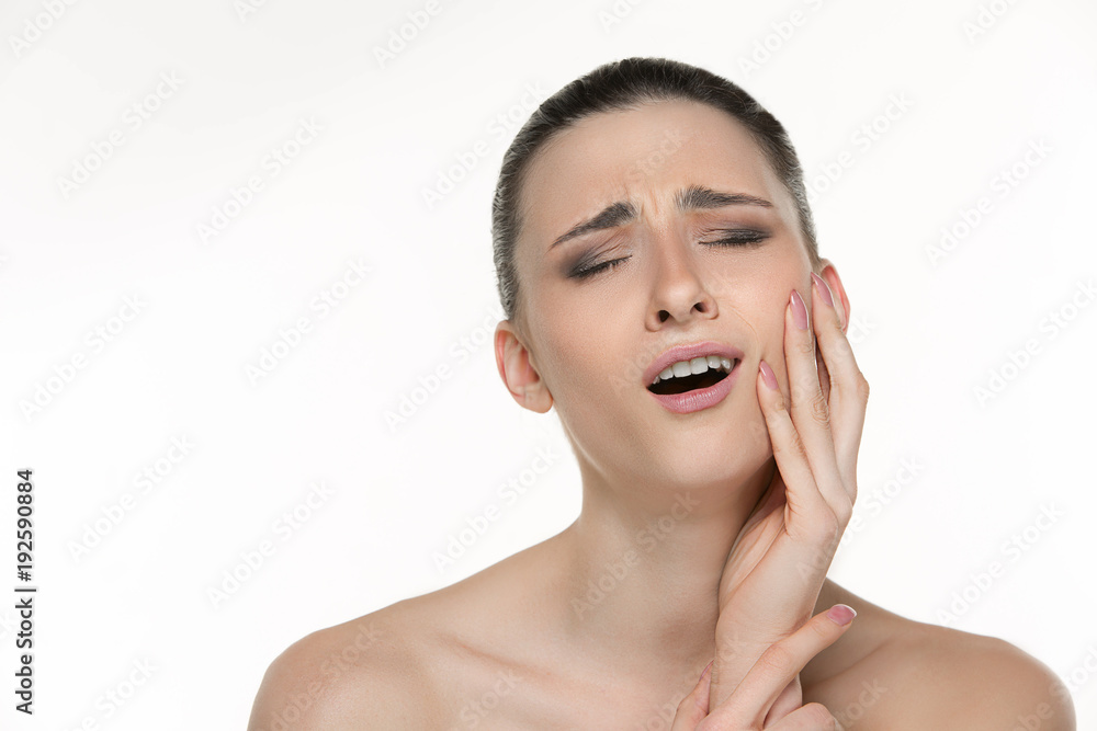 Closeup portrait of young woman suffering from terrible tooth pain, touching pressing her cheek. Dental care and toothache. Closeup portrait of young woman suffering from terrible tooth pain, touching pressing her cheek. Dental care and toothache.