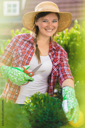 Fröhliche Frau im Garten beim Pflanzenpflege photo