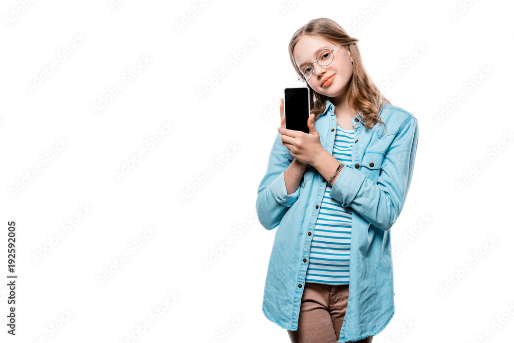 cute ttenage girl in eyeglasses holding smartphone with blank screen and looking at camera isolated on white cute ttenage girl in eyeglasses holding smartphone with blank screen and looking at camera isolated on white