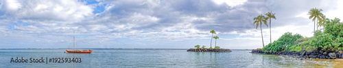 Panoramic view of Kahala Beach with outrigger canoe
