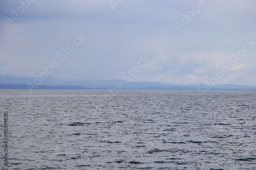 A large reservoir ( lake ) in Kazakhstan under a cloudy and rainy sky