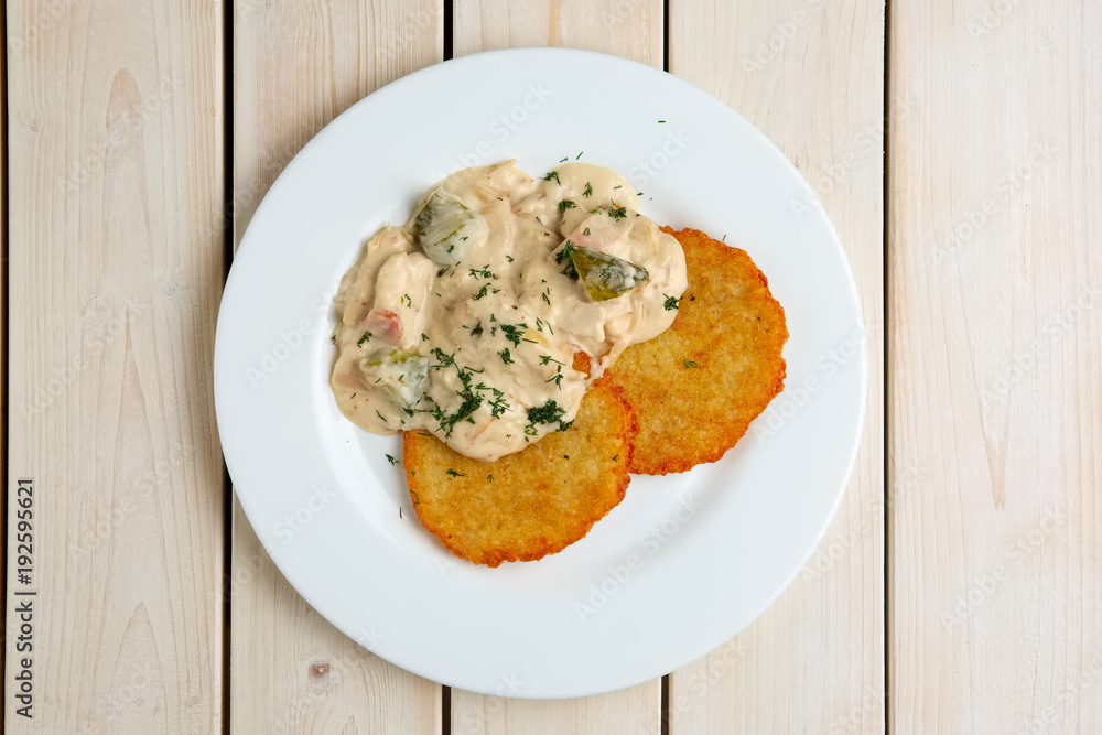 Potato pancakes with flour sauce and pickled cucumber and sausage Potato pancakes with flour sauce and pickled cucumber and sausage
