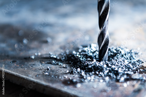 close up of drilling a hole with metal shavings photo