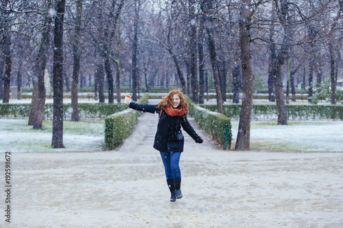 joyful woman running under the rain and snow