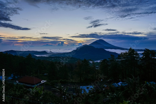 Dawn overlooking the 3 mountains at the same time  Agun  Batur at Bali island. A small smoke from the volcano. Side view with copy space