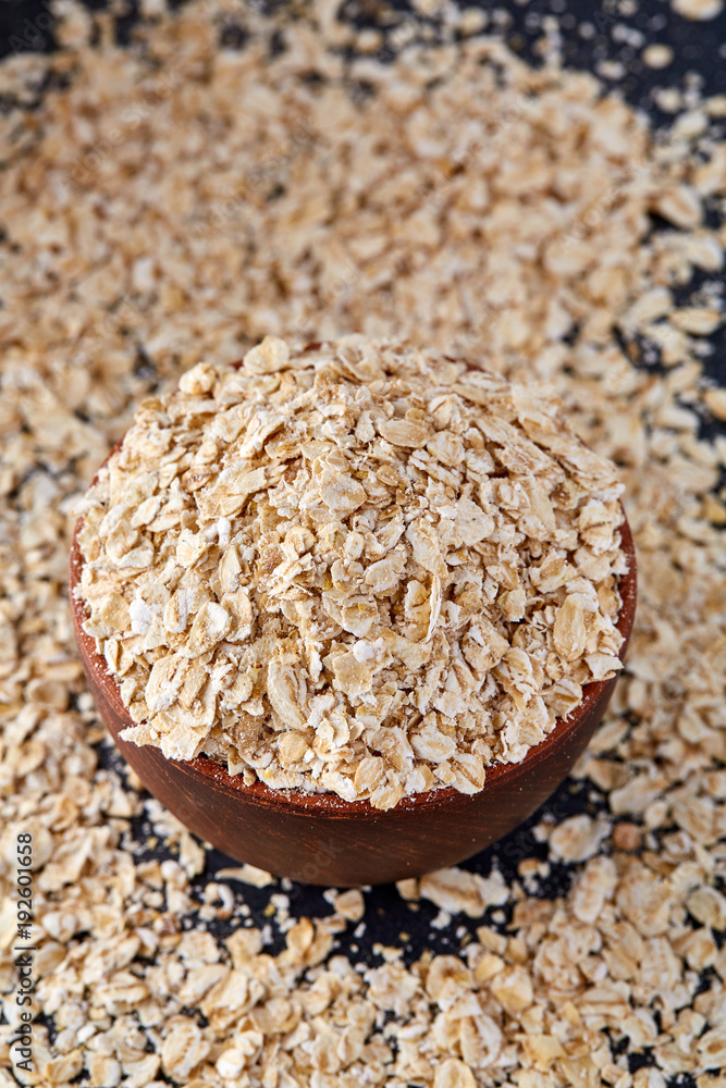 Raw cereal in a clay pot isolated on dark background, top view, vertical, shallow depth of field. Raw cereal in a clay pot isolated on dark background, top view, vertical, shallow depth of field.