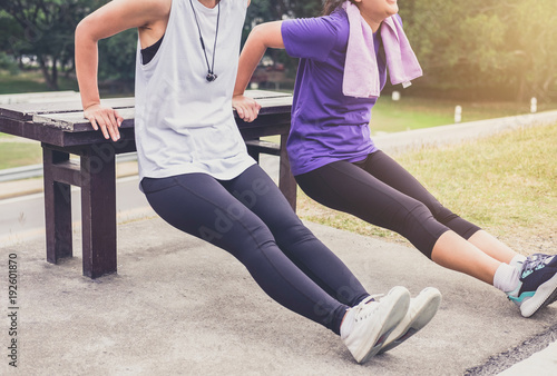 Two attractive young muscular women, Athletic woman doing some stretching push-up workout exercises warm up fitness © Freedomz