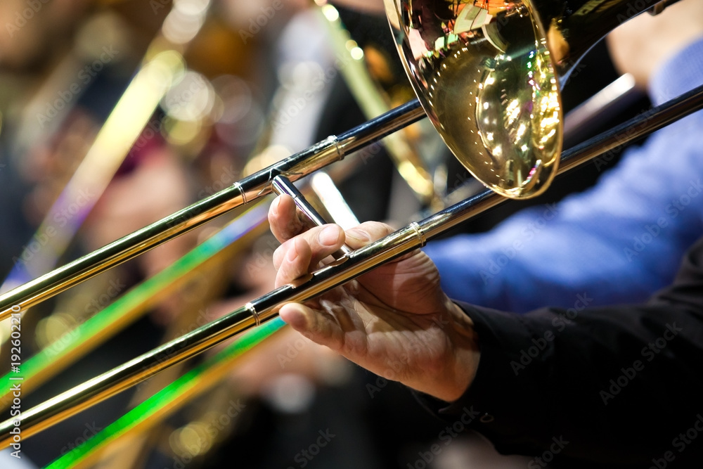 Fototapeta premium Trombone in the hands of a musician in a closeup orchestra 
