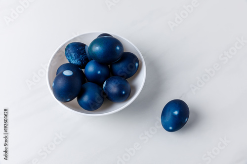 blue painted easter eggs in bowl on white surface