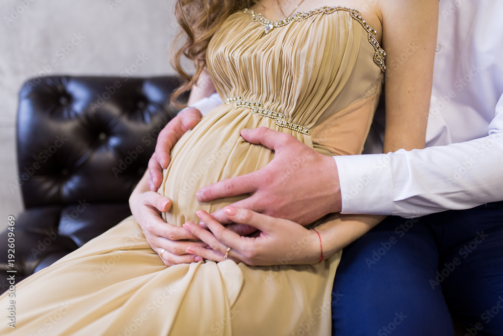 Pregnancy concept couple hugging the pregnant belly. Hands of family