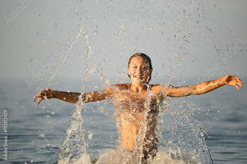 Spray with water. Girl having fun bathing in the sea. © makam1969