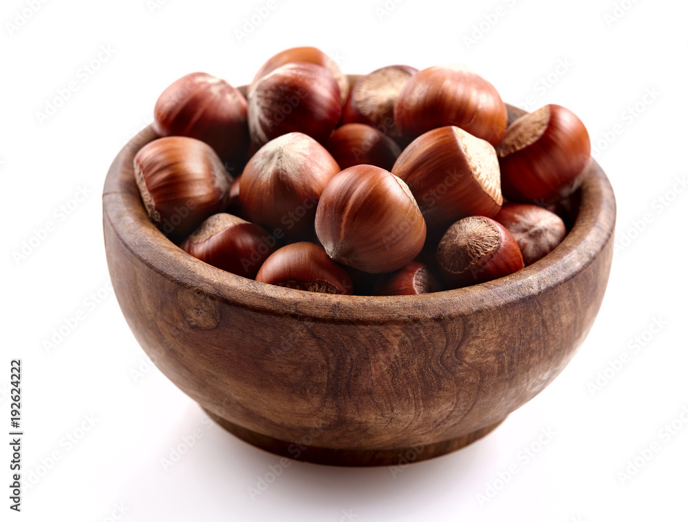 Obraz premium Group of hazelnuts in a bowl on a white background