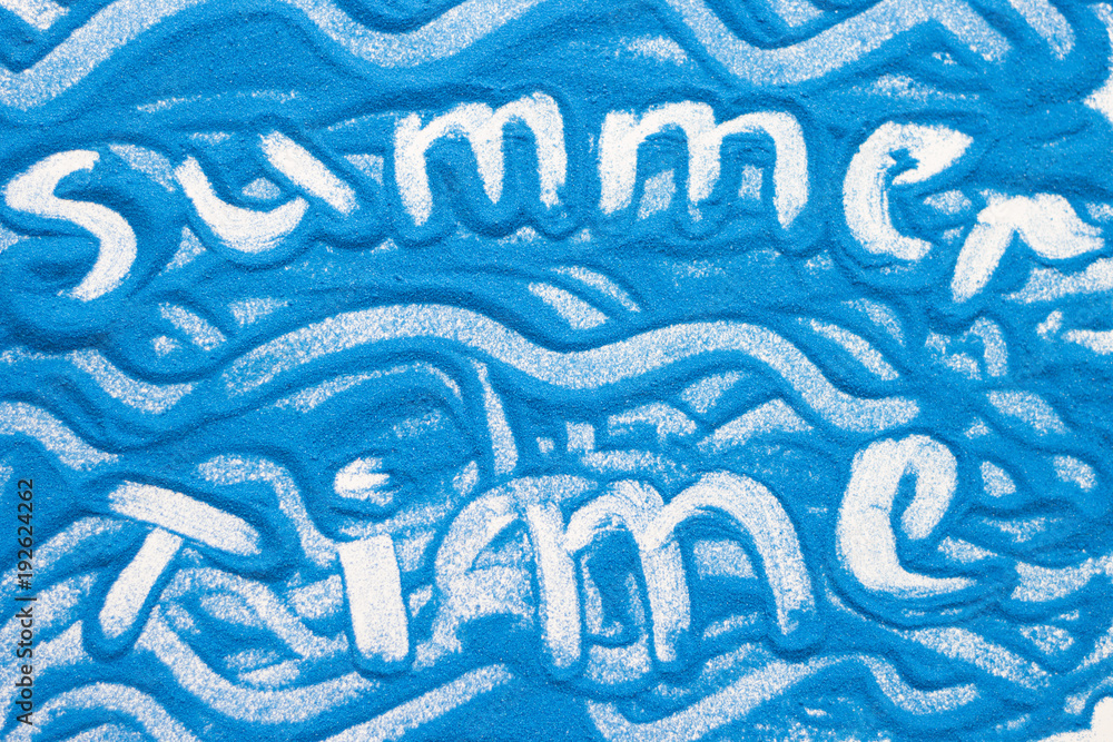 Summer time inscription on a blue colored sand with waves, top view, flat lay Summer time inscription on a blue colored sand with waves, top view, flat lay