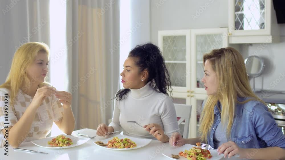 Three young caucasian girls have a dinner at home Three young caucasian girls have a dinner at home