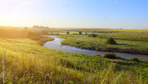 Fototapeta Naklejka Na Ścianę i Meble -  Sunny summer landscape with river.Green hills,fields and meadows.River Upa in Tula region,Russia.Sunrise.Quiet morning.Calm.Warm sunlight.Cloudless clear blue sky.