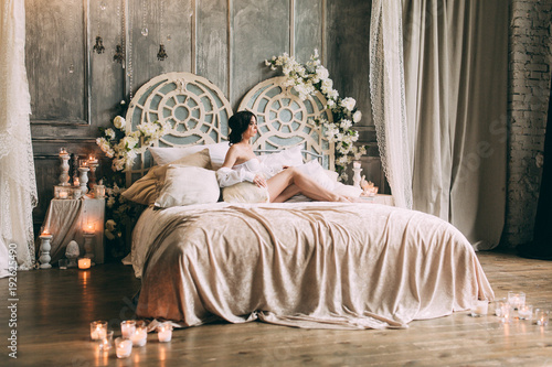 Beautiful bride in lingerie and big white male shirt in bedroom on bed, Boudoir morning of the bride.
