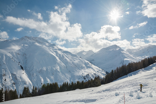 Snowboarder riding down the slope on beautiful sunny winter day in Sedrun ski resort © Michal