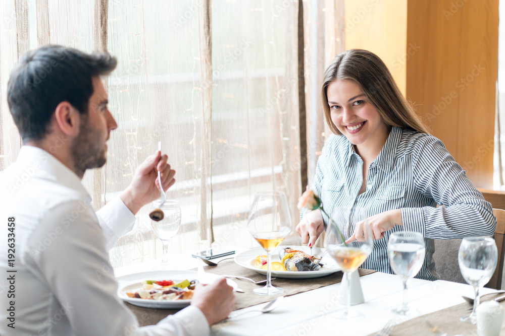 food, christmas, holidays and people concept - smiling couple eating main course at restaurant food, christmas, holidays and people concept - smiling couple eating main course at restaurant