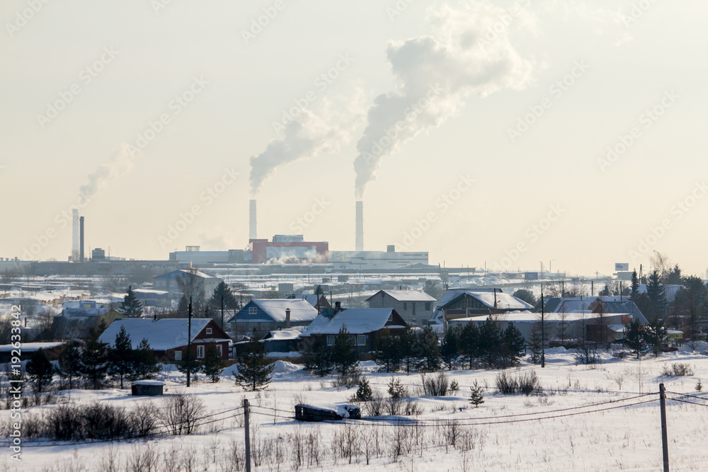 Village houses in the background of a working thermal power plant Village houses in the background of a working thermal power plant