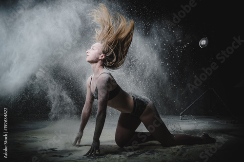 Fototapeta Naklejka Na Ścianę i Meble -  Girl dansing with flour on black background