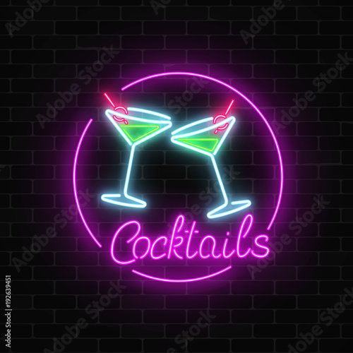 Neon cocktails bar sign on dark brick wall background. Glowing gas advertising with glasses of alcohol shake.