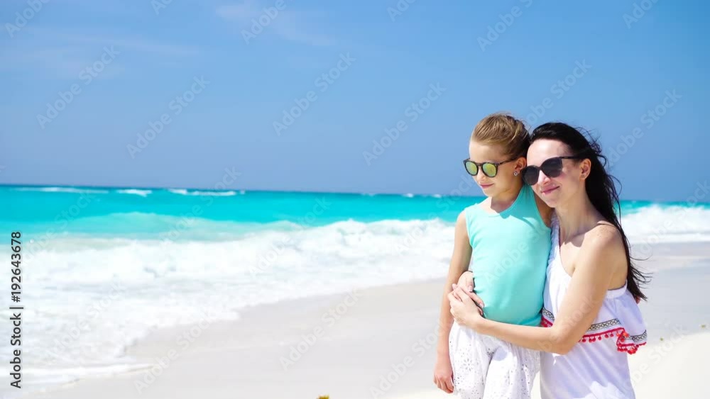 Family fun on white sand. Smiling mother and adorable child playing at sandy beach on a sunny day Family fun on white sand. Smiling mother and adorable child playing at sandy beach on a sunny day
