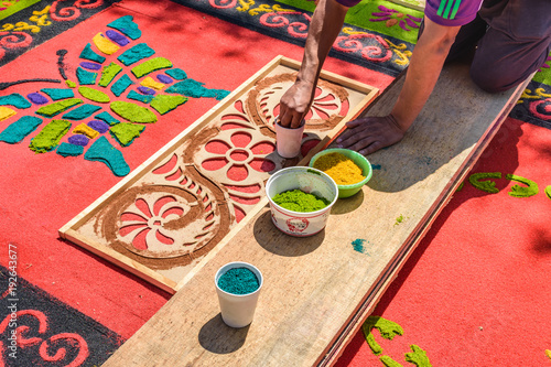 Decorating dyed sawdust Holy Thursday carpet, Antigua, Guatemala