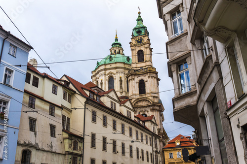 Street view in Prague with St.Nicholas Church in the quarter of Mala Strana. Concept of Europe travel, sightseeing and tourism.