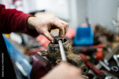 Close up shot of worker hands fixing car ball bearing and conveyor belt