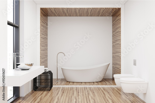 White tub in a white and wooden bathroom