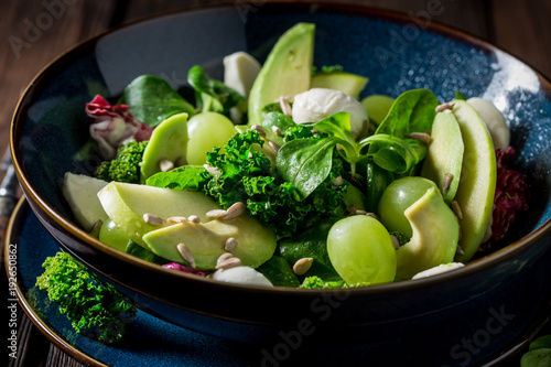 Fotografija Kale salad with avocado, lettuce and grape in blue bowl