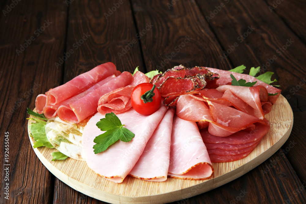 Food tray with delicious salami, pieces of sliced ham, sausage, tomatoes, salad and vegetable - Meat platter with selection Food tray with delicious salami, pieces of sliced ham, sausage, tomatoes, salad and vegetable - Meat platter with selection