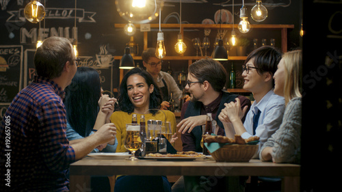 Diverse Group of Young People Have Fun in Bar, Talking, Telling Stories and Jokes. They Drink Various Drinks. They're in the Stylish Hipster Establishment.
