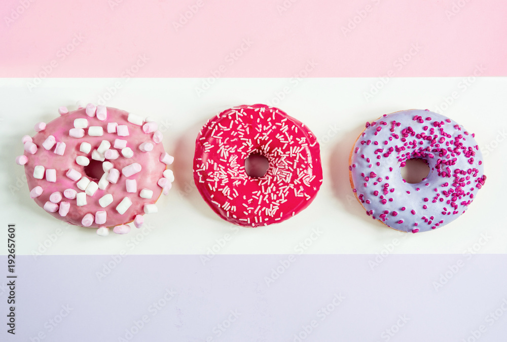 three donuts red pink purple on a three-color background three donuts red pink purple on a three-color background