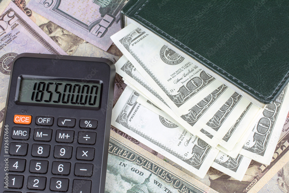 calculator green notebook with dollar bills on the background of money Personal saving concept calculator green notebook with dollar bills on the background of money Personal saving concept
