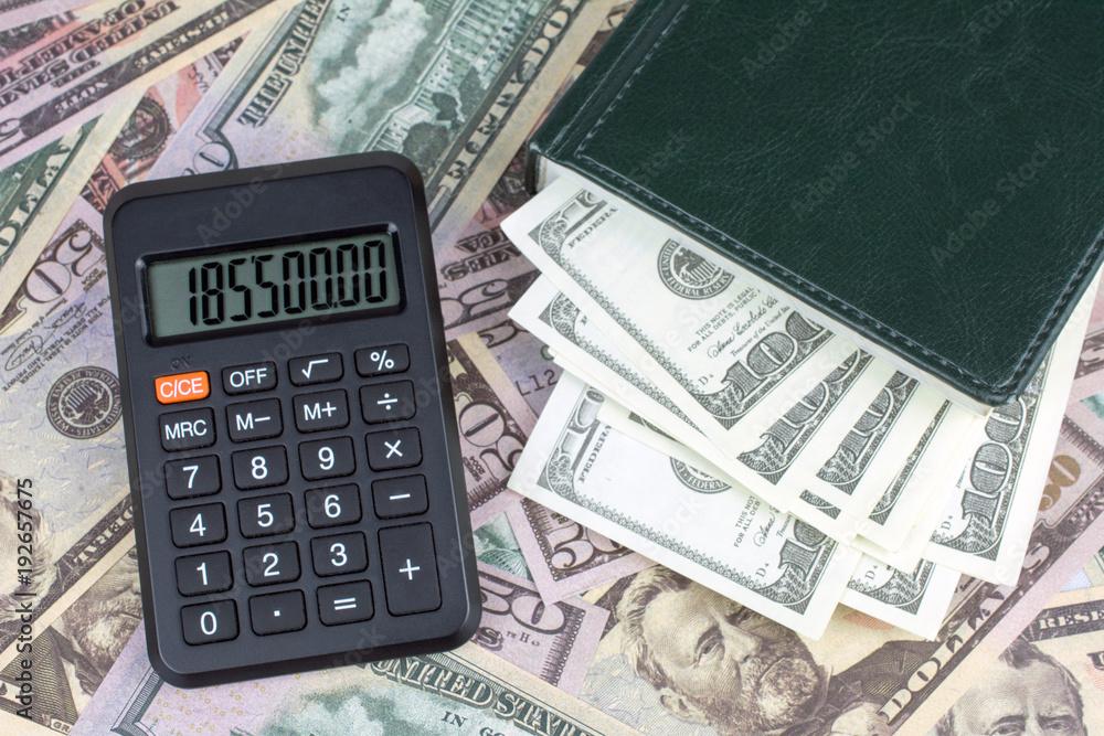 calculator green notebook with dollar bills on the background of money Personal saving concept calculator green notebook with dollar bills on the background of money Personal saving concept