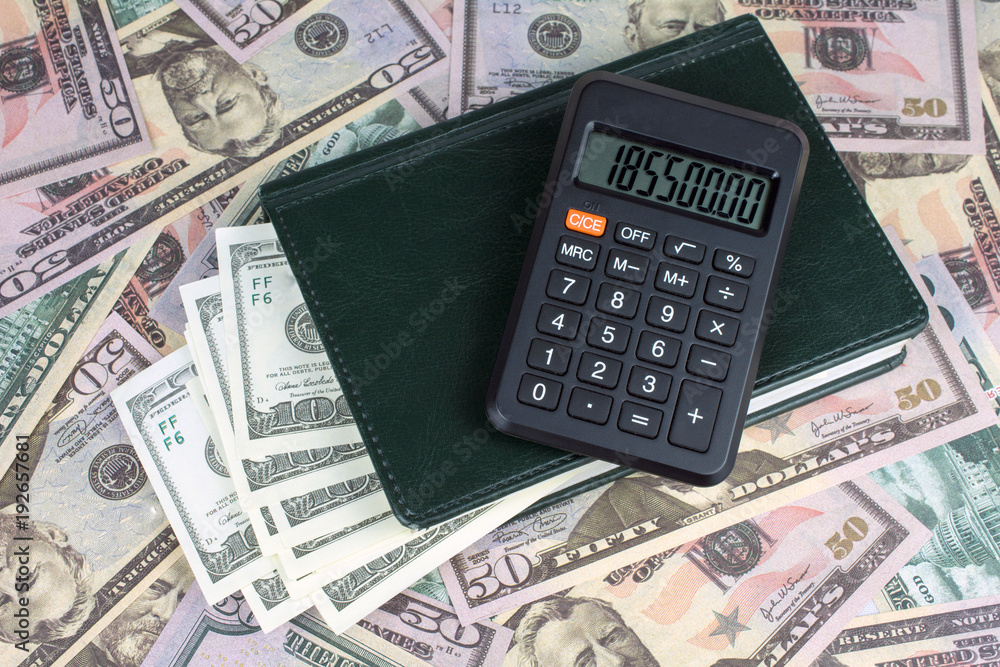 calculator green notebook with dollar bills on the background of money illegally money concept calculator green notebook with dollar bills on the background of money illegally money concept