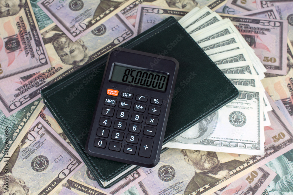 calculator green notebook with dollar bills on the background of money illegally money concept calculator green notebook with dollar bills on the background of money illegally money concept