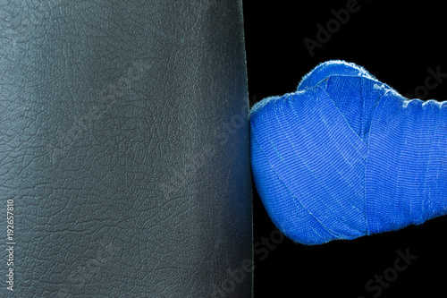 Bandaged Hands Boxing Bag Punch Blue Bandages copyspace, black background, selective focus photo