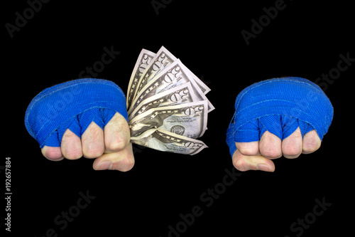 Hands of a fighter Blue bandages keeps dollar bills copyspace, black background, selective focus photo