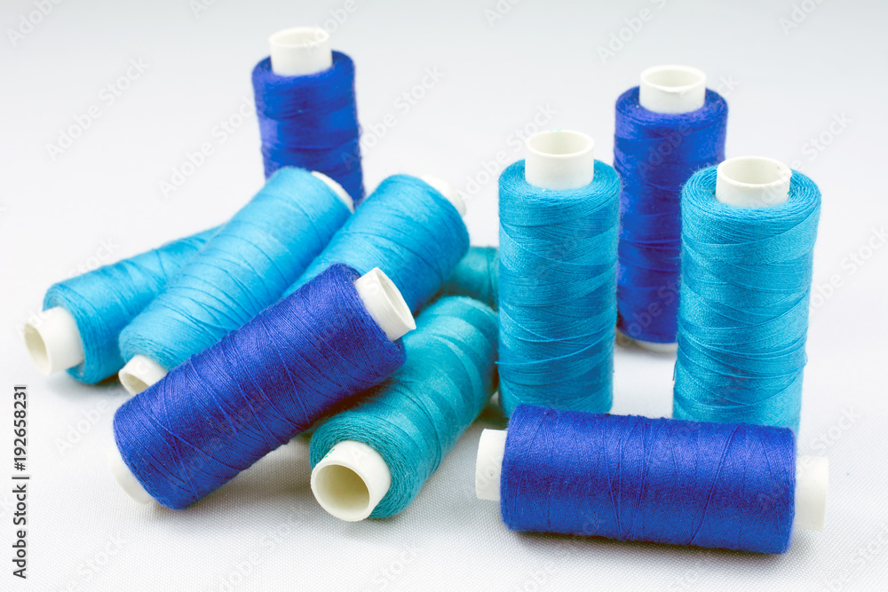 blue threads on reels selective focus, white background blue threads on reels selective focus, white background