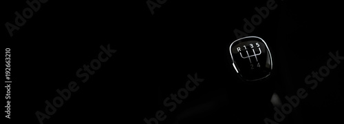 Manual transmission gear shift, on dark backgroun. For text.
