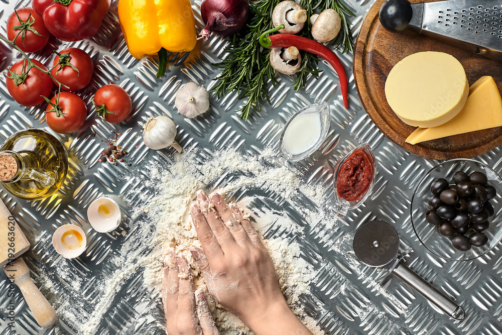 Pizza dough with ingredients on iron background, shot from above. Pizza dough with ingredients on iron background, shot from above.