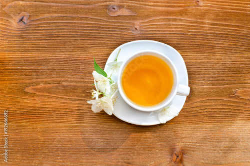 White mug of tea on a brown wooden table. Close up, top view